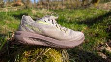 Merrell Morphlite trail running shoe sitting on a grassy log