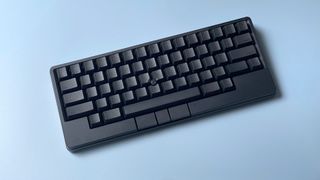 The HHKB Studio mechanical keyboard against a blue background.