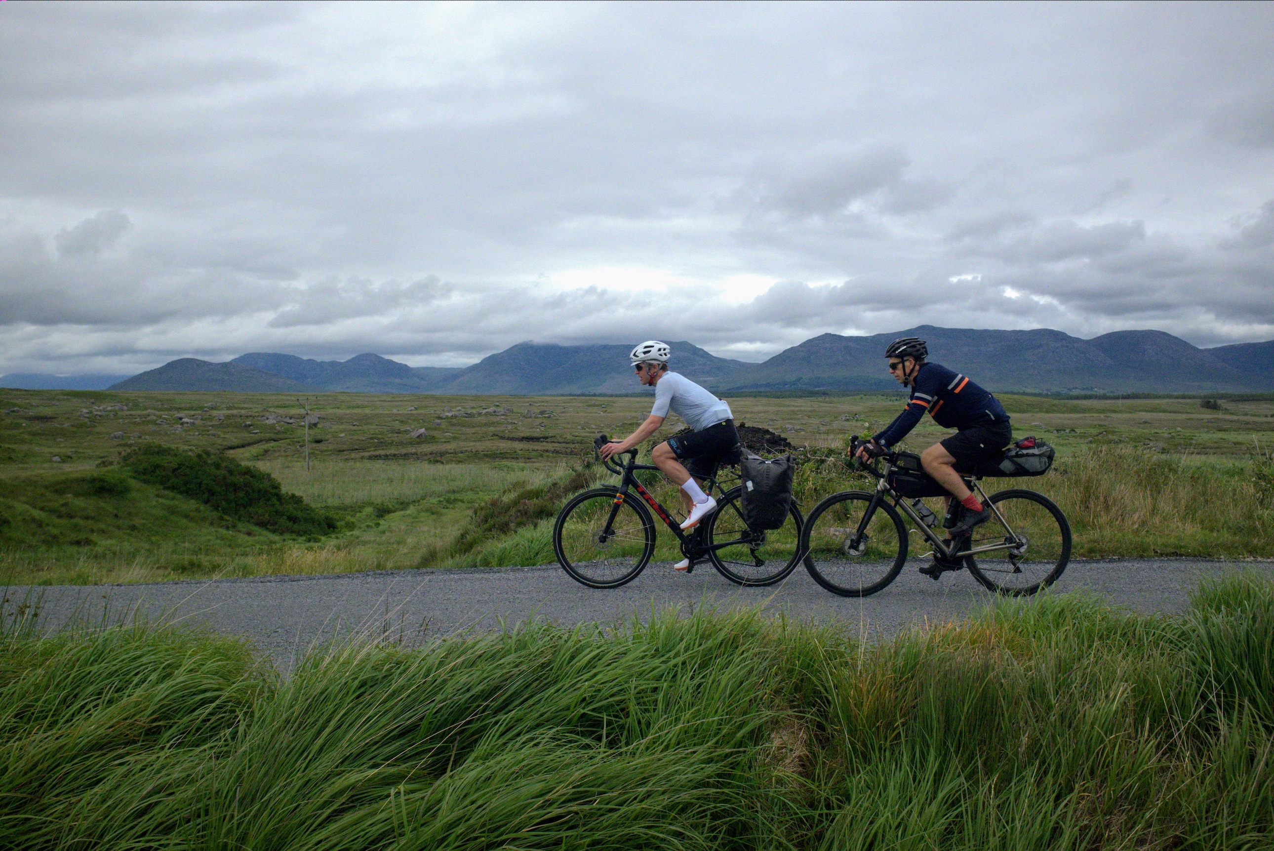 David Bradford and Simon Thomas riding across bogland with the Maumturk mountains in the background