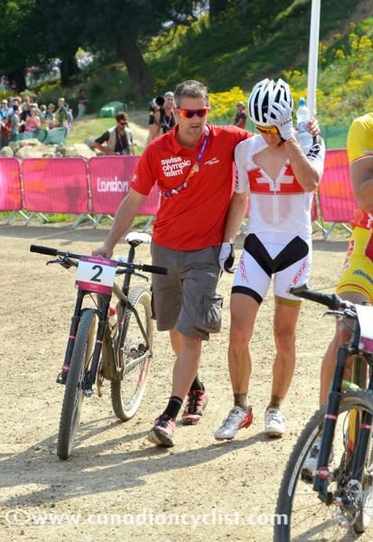 Swiss team staff console Nino Schurter after missing out on the gold medal