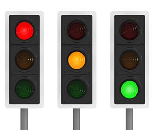 row of traffic lights showing red amber green on white background