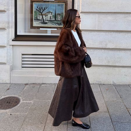 Influencer Aimee Song wearing a fuzzy brown cardigan, brown leather skirt, and black flats
