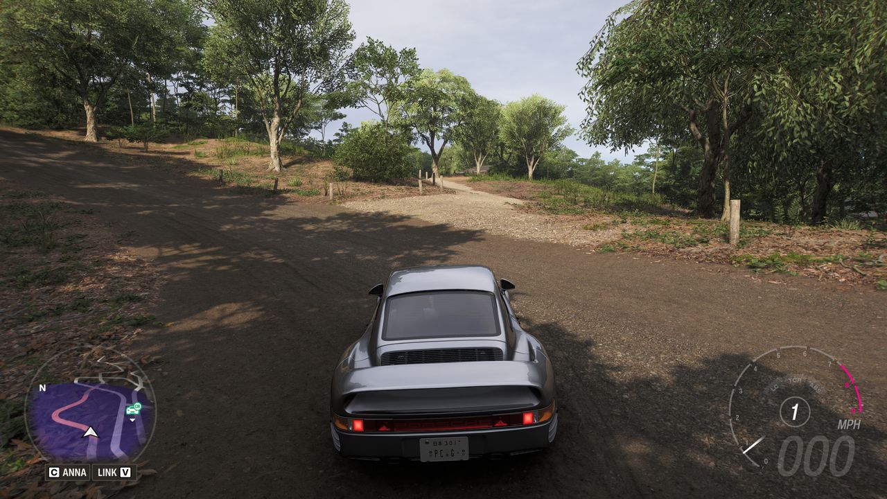 Forza Horizon 6 Barn Finds: A player parked on a dirt road, looking at a narrower path leading into a clearing with a barn.