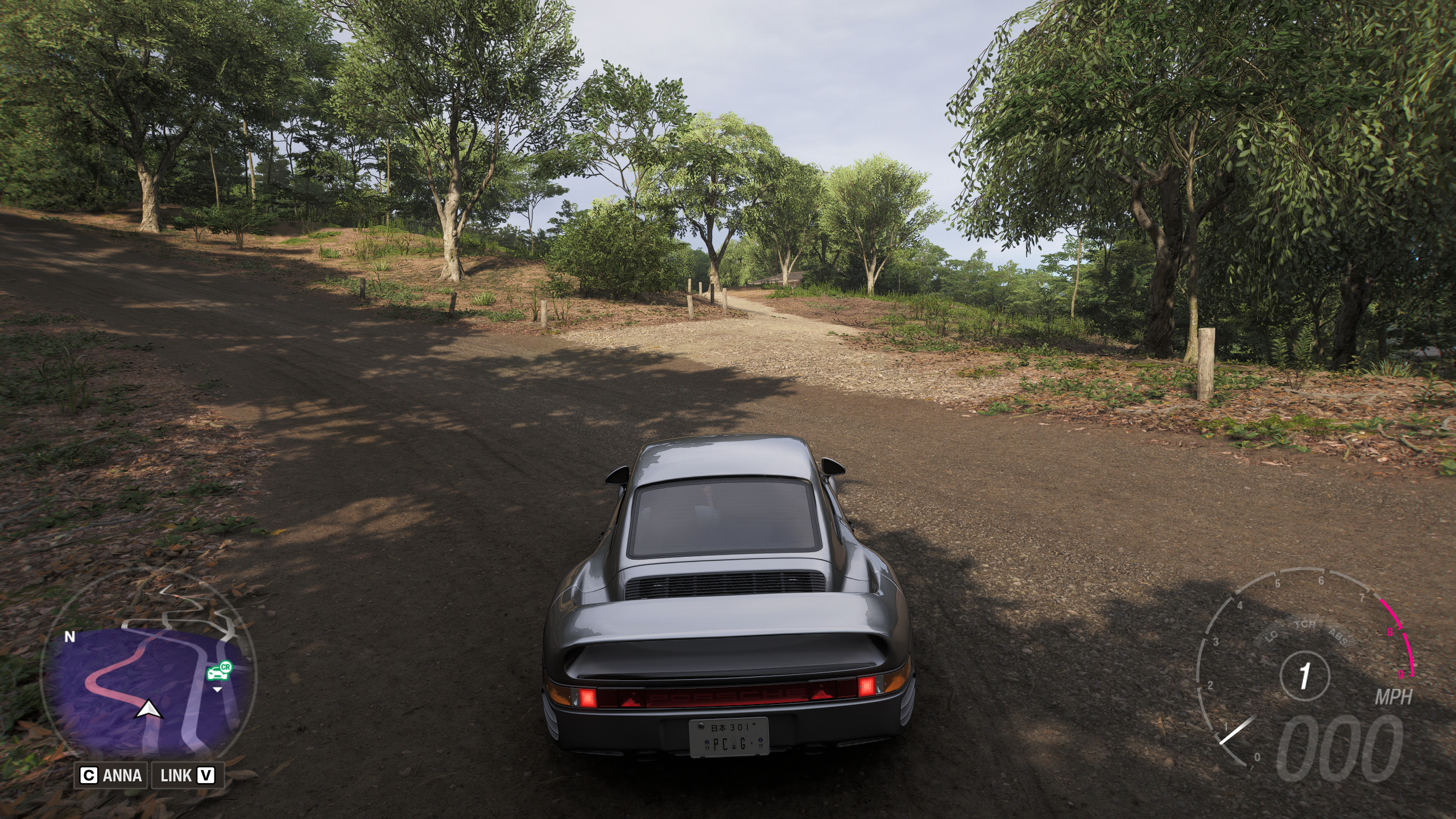 Forza Horizon 6 Barn Finds: A player parked on a dirt road, looking at a narrower path leading into a clearing with a barn.