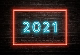 2021 in neon lights against a brick backdrop