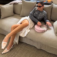 an influencer wearing a cardigan and silk skirt