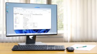 Windows 11 desktop shown on an all-in-one PC on a desk