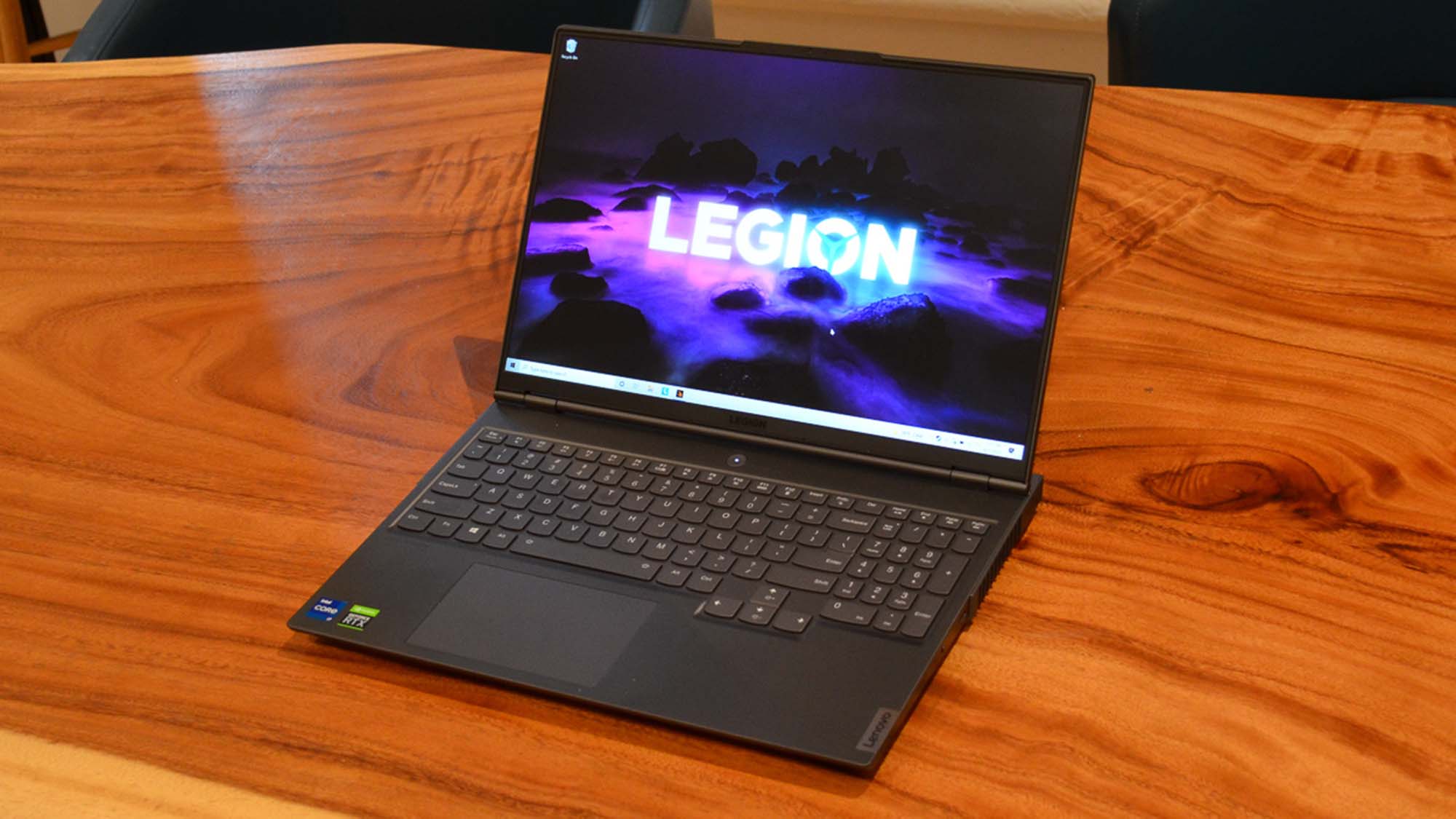En Lenovo Legion 7 står öppnad på ett träfärgat bord.