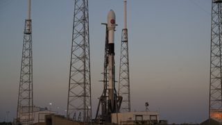 white and black spacex rocket with lightning towers on launch pad