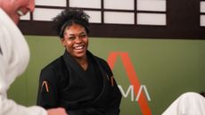 Woman in black martial arts uniform smiling