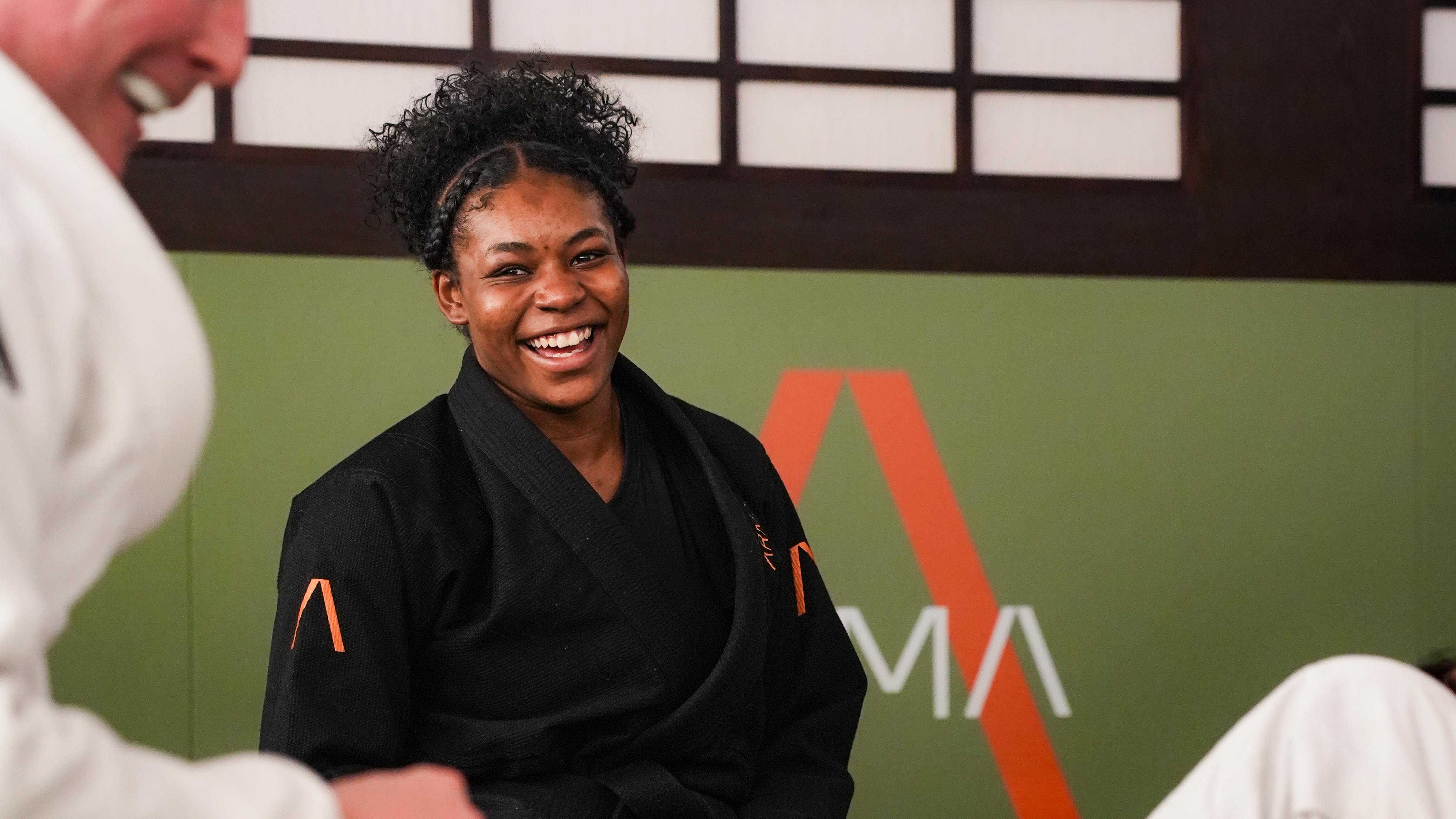Woman in black martial arts uniform smiling 
