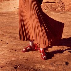 person wearing fisherman sandals waist-down photo with pleated skirt
