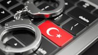 Handcuffs lying on a keyboard. The keyboard's enter key features the T&uuml;rkiye flag.