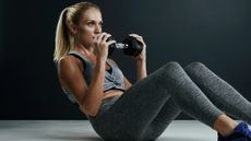 Woman doing a sit-up with a dumbbell