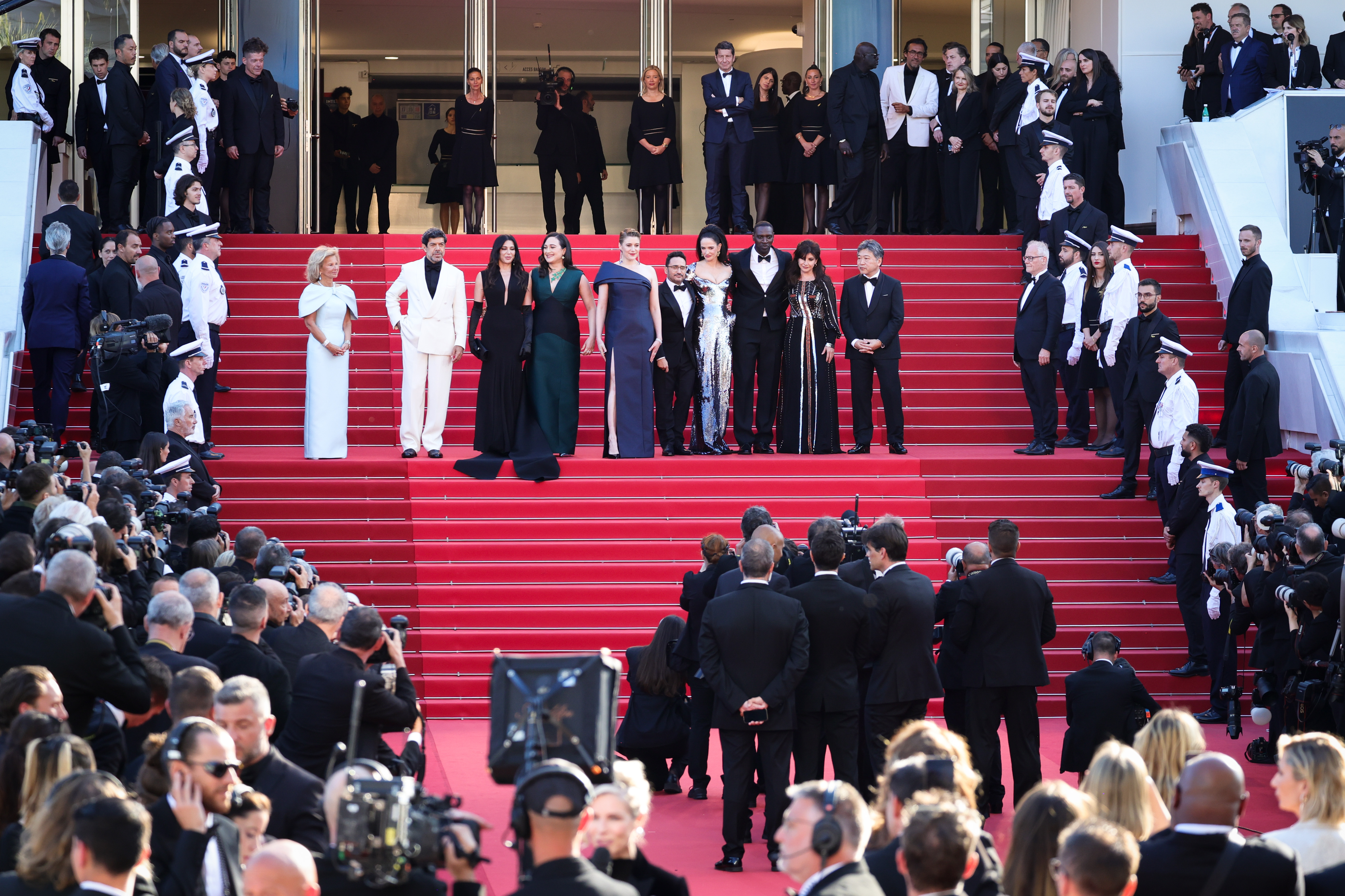 Men and women in black tie on a red carpet in Cannes, France