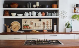 galley kitchen with white cupboards and wooden surfaces by wearth london