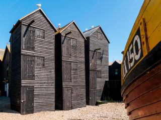 Traditional tall wooden huts for fishing net storage East Cliff Hastings UK