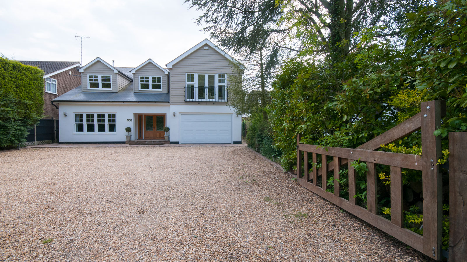 New England style house with large gravel driveway