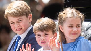 Prince George, Charlotte and Louis ride in a carriage during Trooping The Colour