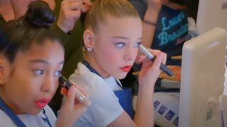 Dancers apply makeup on Dance Moms: A New Era.