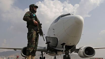 A Taliban fighter stands guard at Hamid Karzai International Airport in Kabul