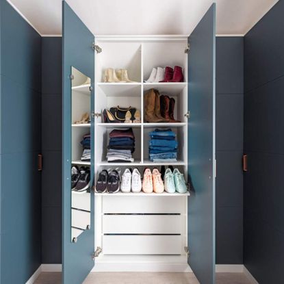 Blue wardrobe with folded items and shoes in there