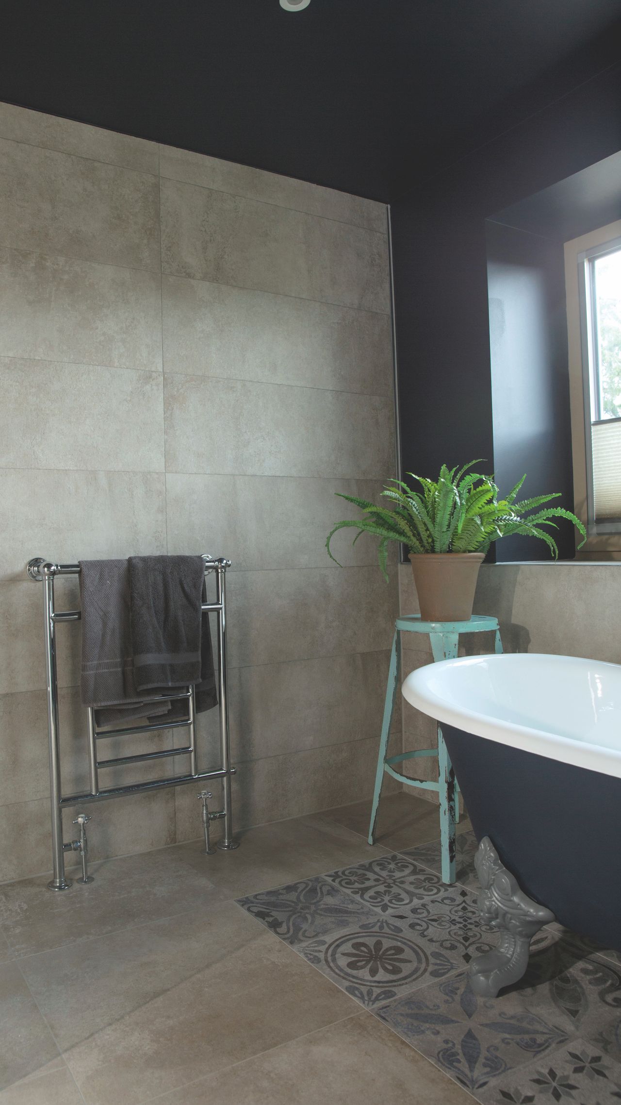 The en suite bathroom features a claw-footed freestanding roll-top bath sourced from The Iron Bath Company, painted in a mid-grey tone.