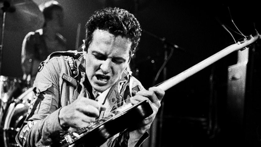 Joe Strummer, with Topper Headon behind, performing live onstage