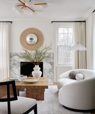 White living room with marble fireplace and coffee table