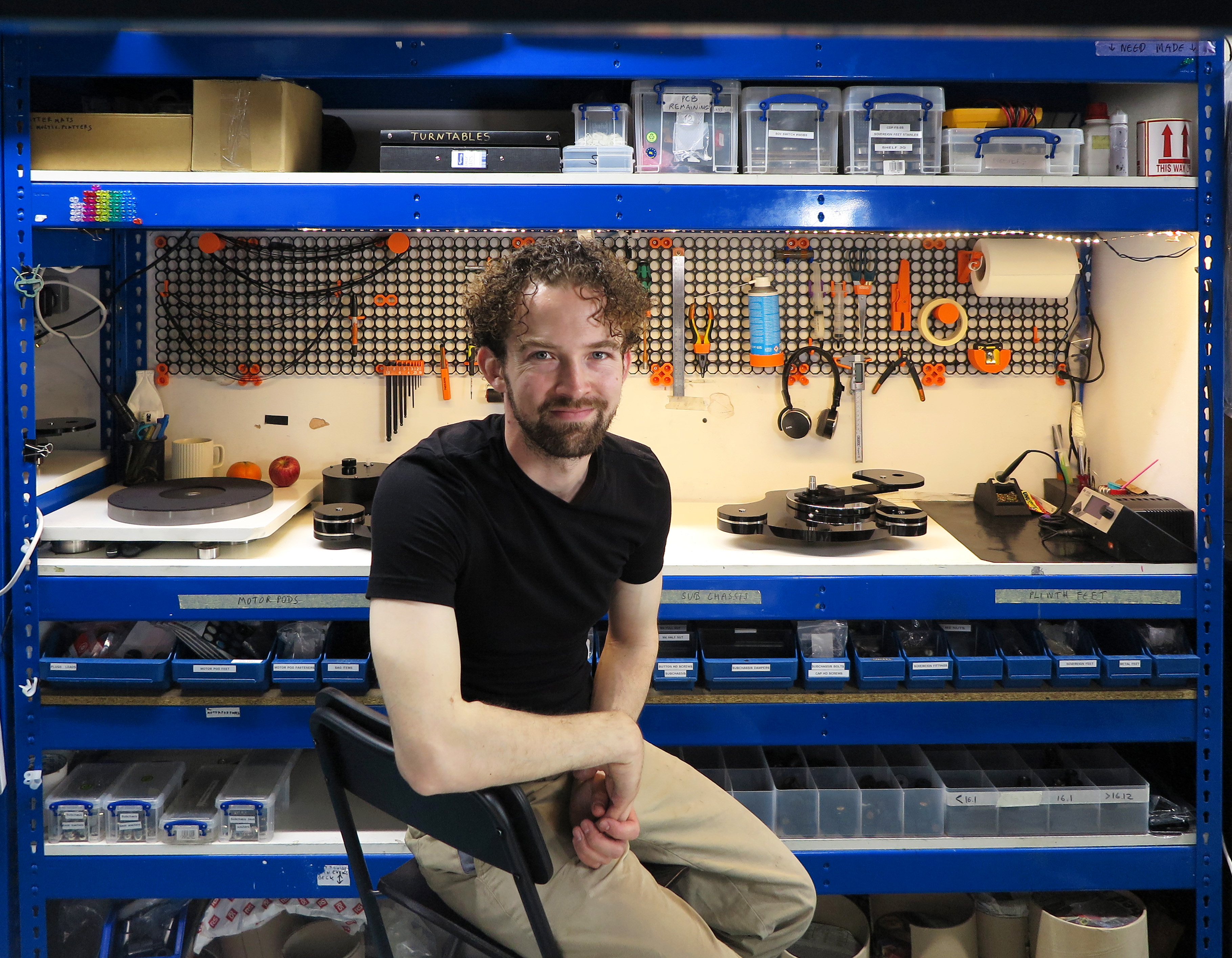 Origin Live's David Baker sitting on a chair in a workshop