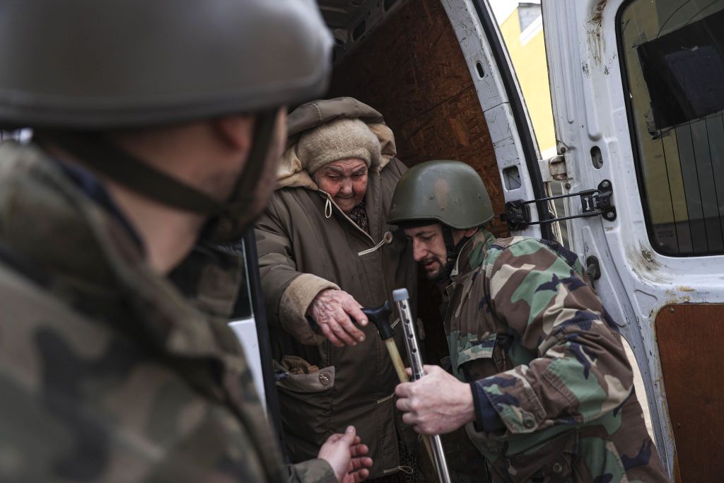 Ukrainian soldier evacuating old woman from Irpin