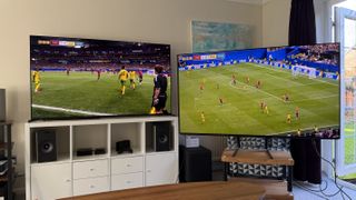 Two 65-inch TVs showing football, pictured in a living room