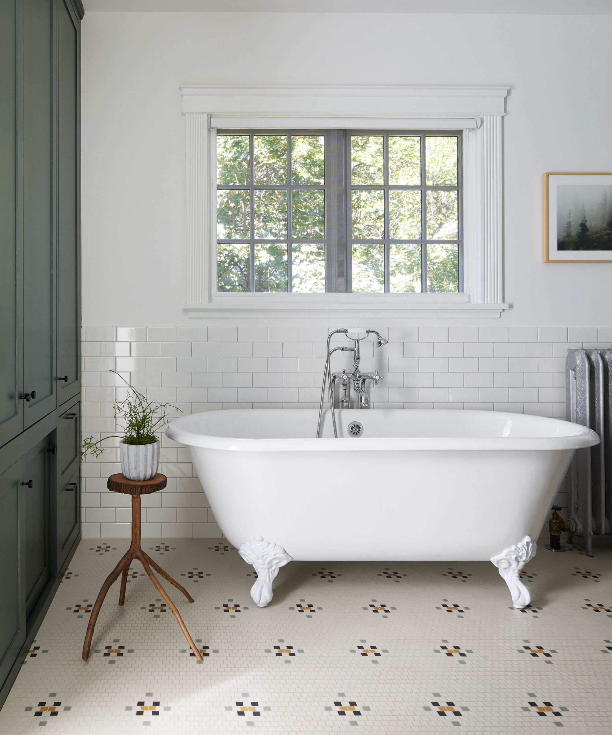 A bathroom with a freestanding bathtub and patterned tile on the ground