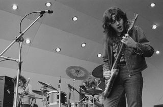 Irish singer and guitarist Rory Gallagher (1948-1995) performs live on stage with bassist Gerry McAvoy and drummer Wilgar Campbell (1946-1989) at the Crystal Palace Garden Party II at Crystal Palace Bowl in London, England on 31st July 1971.