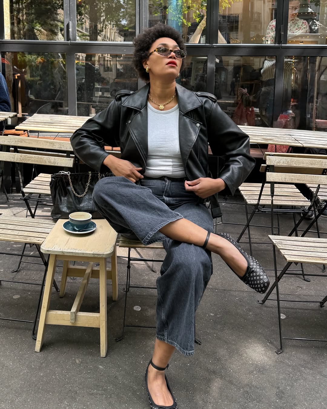 Influencer Le&amp;#769;na Farouil wearing black jeans, a biker jacket and studded ballet flats.