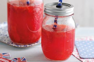 close up of strawberry drink in a jar with a straw