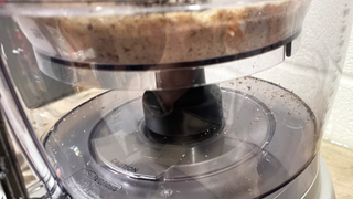 Image shows almond dust that has escaped from inside the smaller work bowl of the Cuisinart Expert Prep Pro into the larger work bowl.