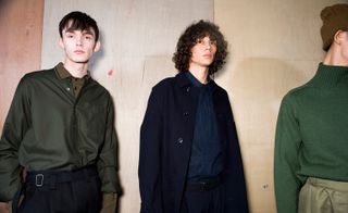 Models wear navy trench, green wool jumper, khaki shirt and tailored trousers.