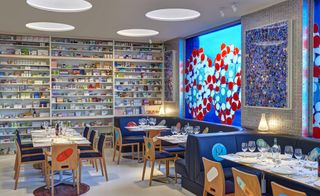 Cabinets stacked full of medicines line the walls, bar stools are topped with giant squishy paracetamol pills and glinting helix strands decorate a bar