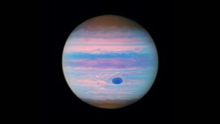 a planet with bands in its atmosphere glows in pinks and blues
