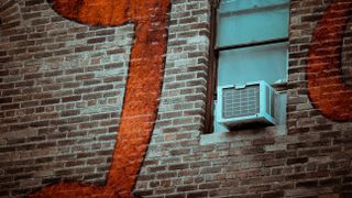 Air conditioner in the window of a brick building