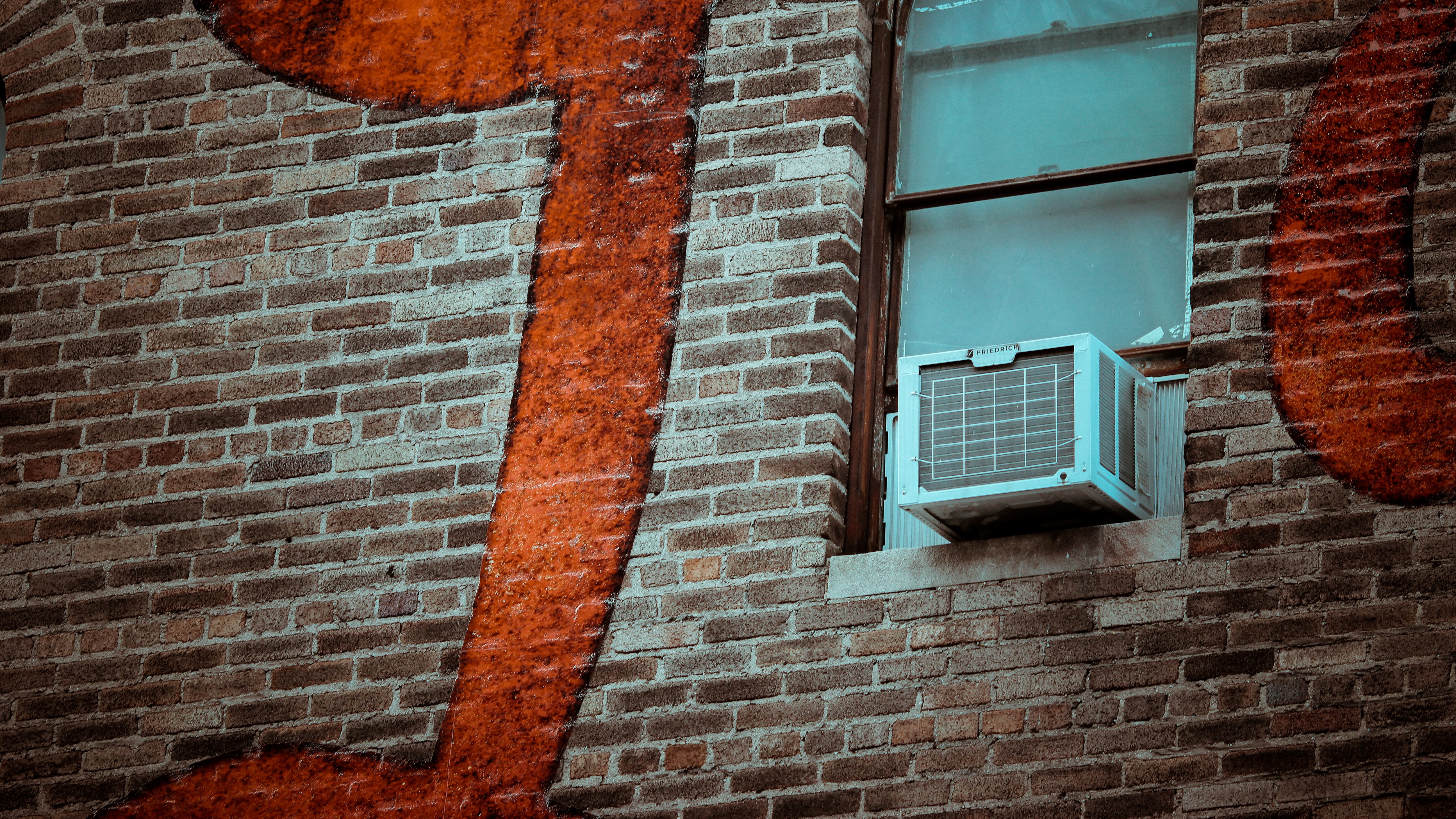 Air conditioner in the window of a brick building