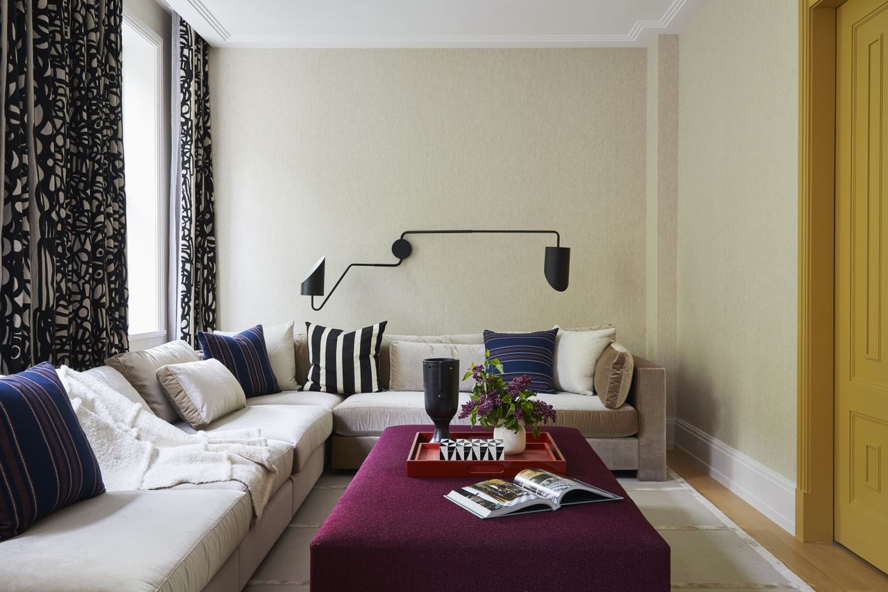 taupe living room with violet ottoman, cream couch
