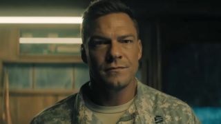 Alan Ritchson in military gear in Reacher. 