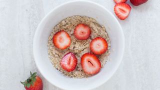 A bowl of oatmeal topped with strawberries