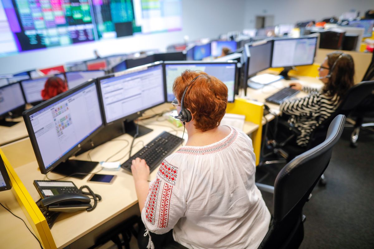 911 operator sitting in front of multiple computer monitors