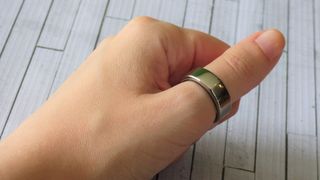 Oura smart ring on a person's thumb