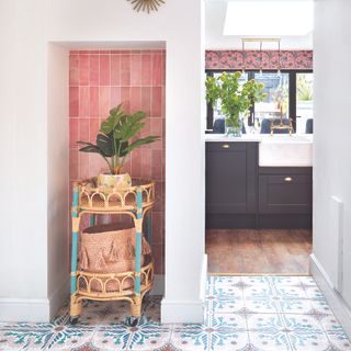 Kitchen with pink tiled alcove with a rattan planter inside.