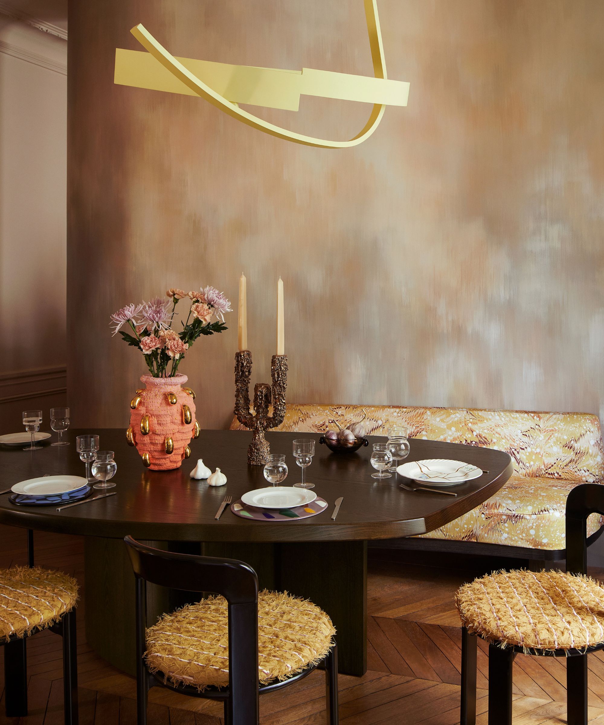 Living room with large dark wooden dining table and chairs upholstered in a textured fabric