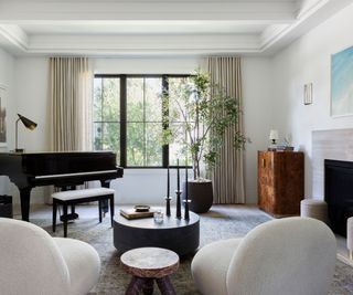 living room with piano and white occasional chairs